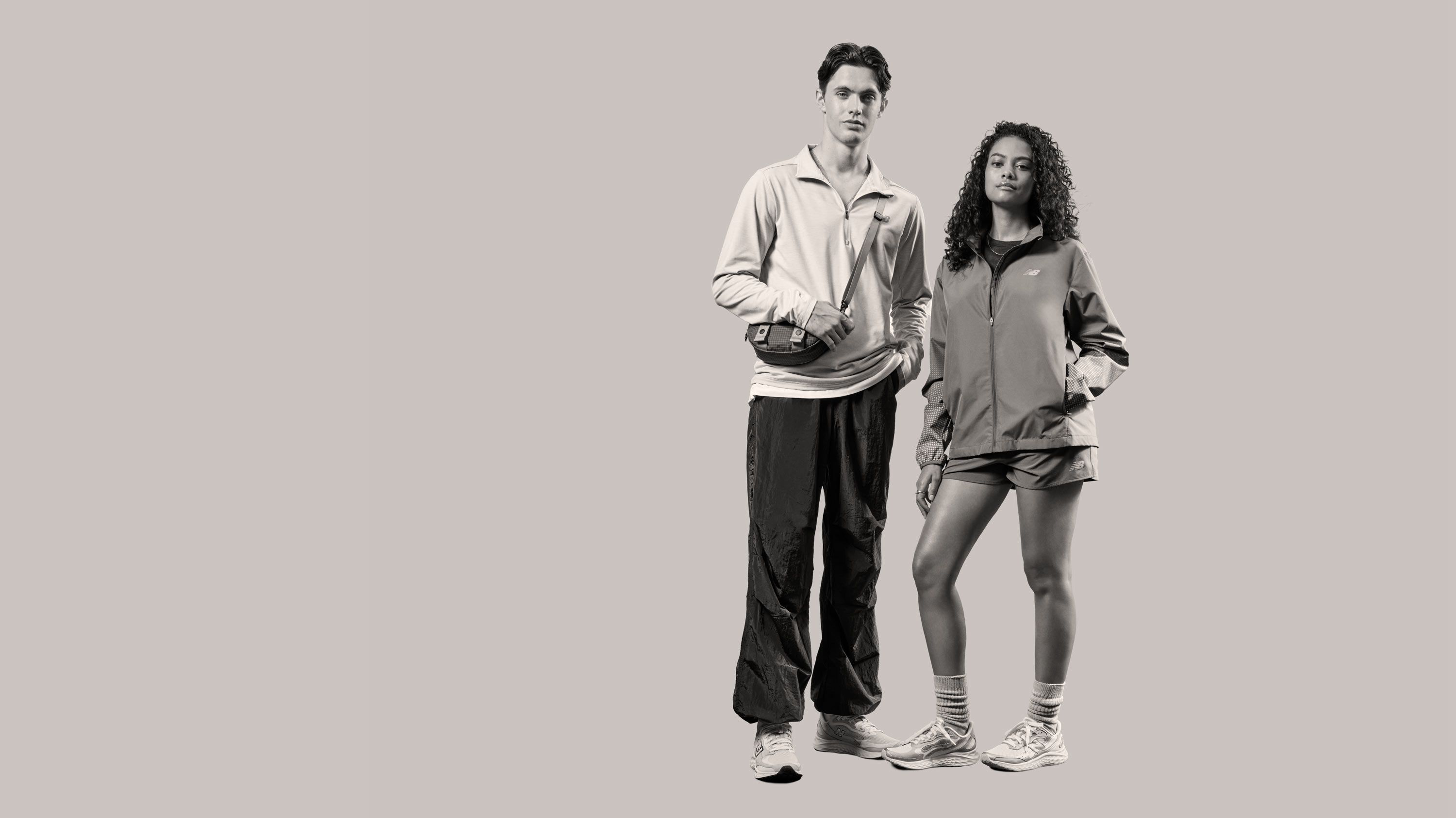 Para modeli w ubraniach New Balance na tle ceglanej ściany.