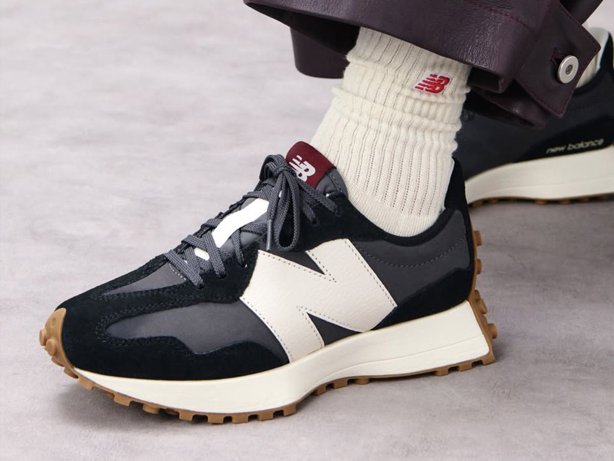 Zbliżenie na stopę osoby w butach New Balance, połączonych z białymi skarpetkami i casualowym strojem. - zdjęcie